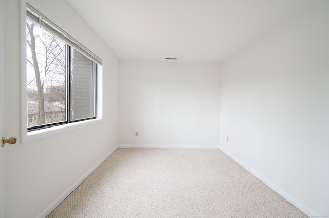 unfurnished room featuring carpet, plenty of natural light, visible vents, and baseboards