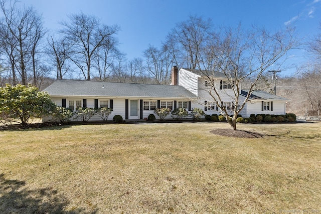 view of front of home with a chimney and a front yard