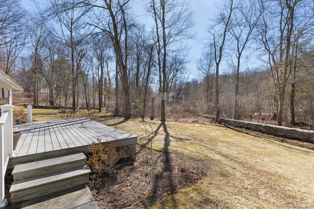 view of yard with a wooded view and a wooden deck