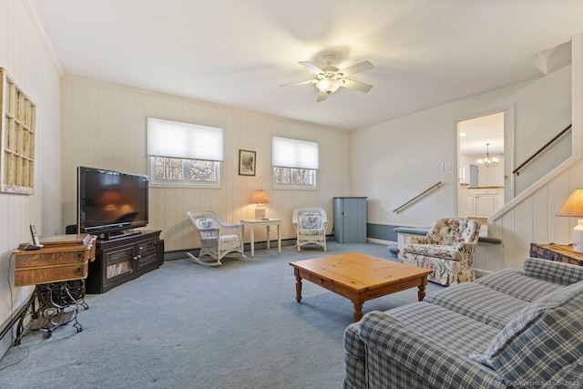 carpeted living area with a baseboard radiator and ceiling fan with notable chandelier