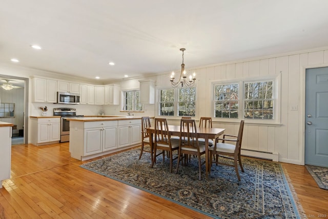 dining room featuring recessed lighting, a baseboard heating unit, light wood-style floors, and an inviting chandelier