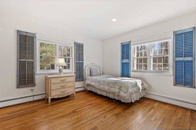 bedroom featuring recessed lighting, a baseboard radiator, and light wood-style flooring