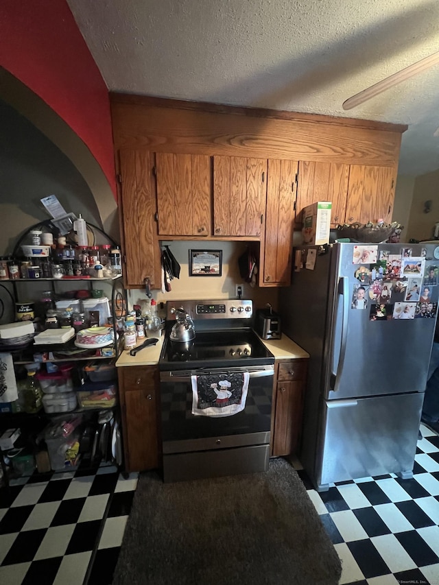 kitchen with stainless steel appliances, dark floors, light countertops, and brown cabinets