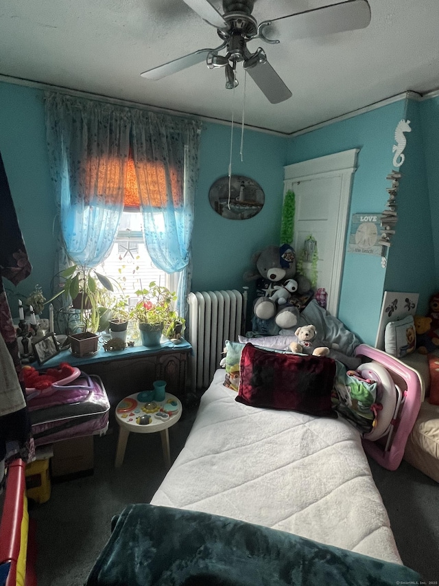 bedroom featuring a ceiling fan and radiator heating unit