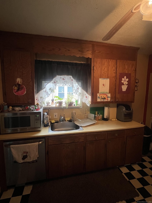 kitchen featuring white microwave, tile patterned floors, a sink, light countertops, and stainless steel dishwasher