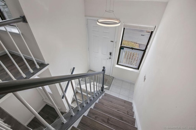 staircase with wood finished floors and baseboards