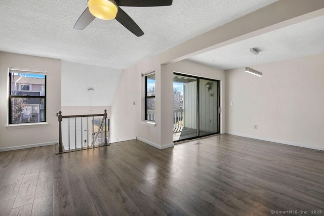 unfurnished room featuring a textured ceiling, baseboards, and wood finished floors