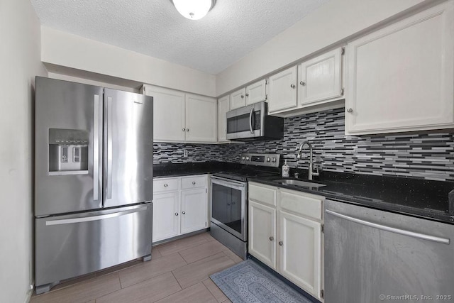 kitchen featuring appliances with stainless steel finishes, a sink, and white cabinets