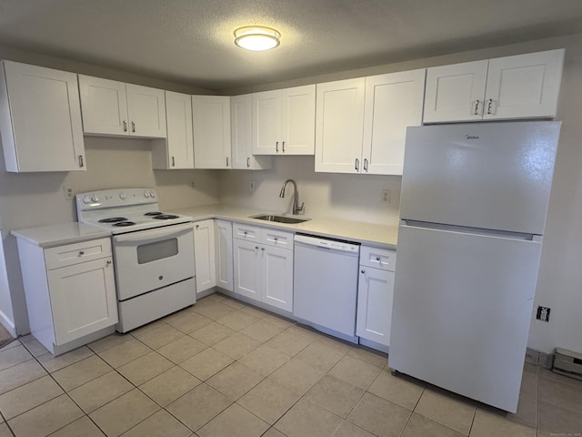 kitchen featuring light countertops, white appliances, a sink, and white cabinets