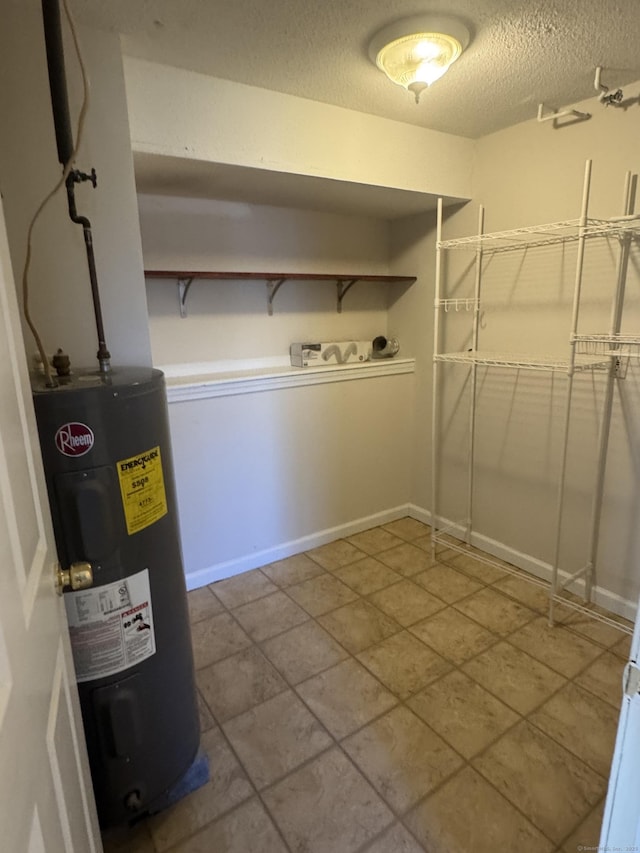 interior space with water heater, a textured ceiling, and baseboards