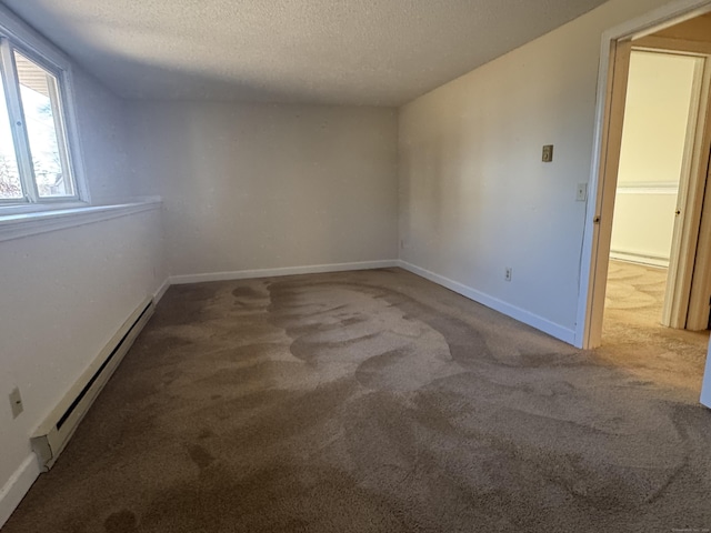 carpeted spare room featuring a baseboard radiator, a textured ceiling, and baseboards