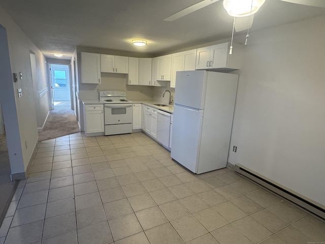 kitchen with white appliances, a baseboard radiator, white cabinets, and a sink