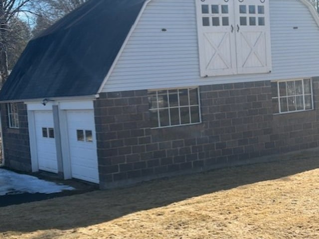 view of side of home with a gambrel roof