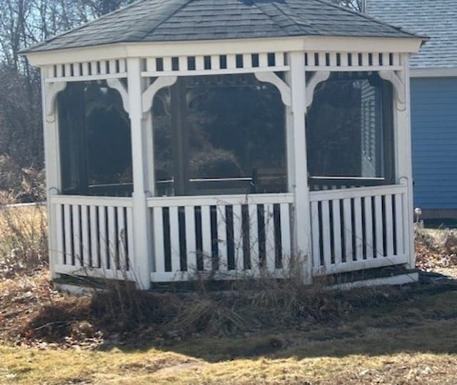 view of home's exterior with roof with shingles and a sunroom