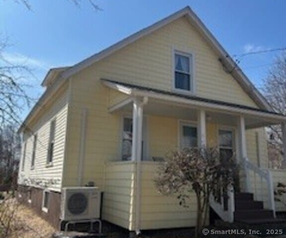 view of home's exterior with covered porch and ac unit