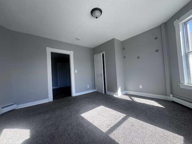 carpeted empty room with a textured ceiling, a baseboard heating unit, a baseboard radiator, and baseboards