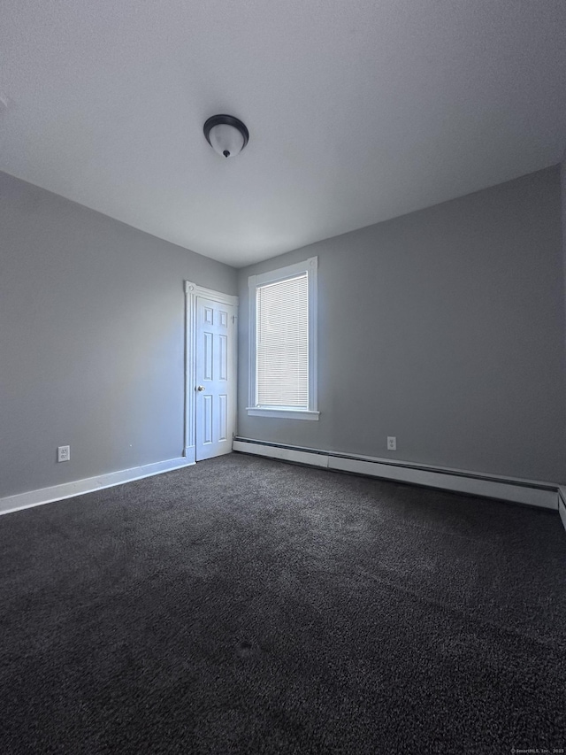 unfurnished room featuring a baseboard heating unit, dark colored carpet, and baseboards