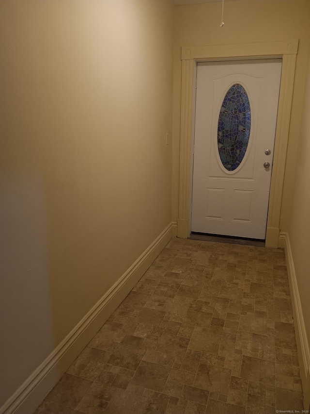 doorway to outside featuring baseboards