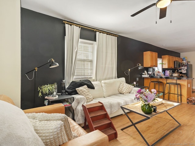 living room with wood finished floors and a ceiling fan