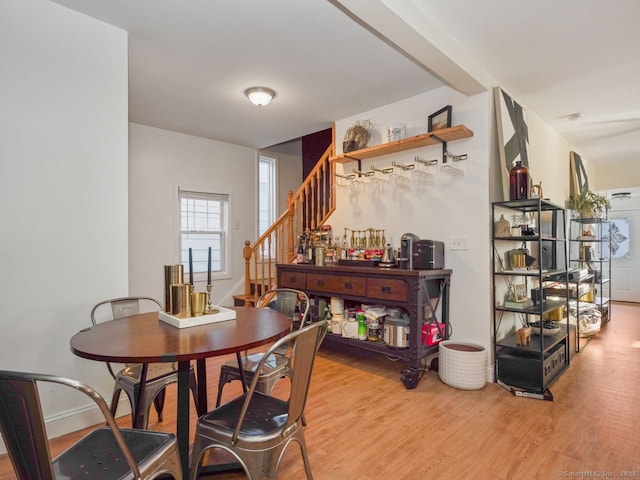 dining room with stairway, baseboards, and wood finished floors