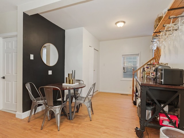 dining room featuring light wood finished floors and baseboards