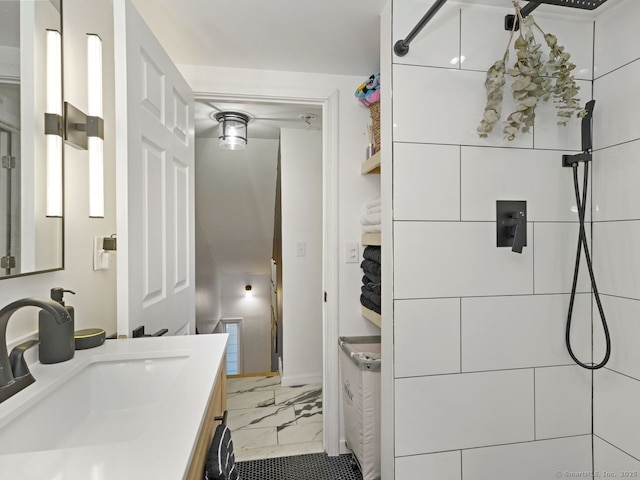 bathroom with marble finish floor, walk in shower, and a sink