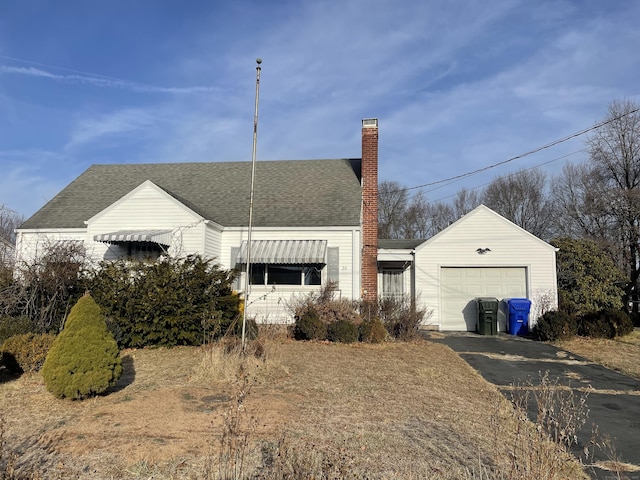 view of front of home featuring aphalt driveway, a chimney, roof with shingles, and an attached garage