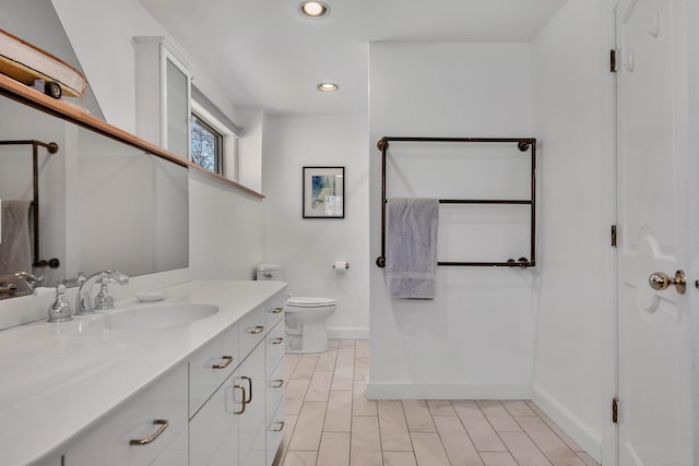 bathroom featuring toilet, wood finished floors, recessed lighting, baseboards, and vanity