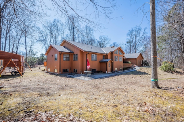 rear view of house featuring a shingled roof