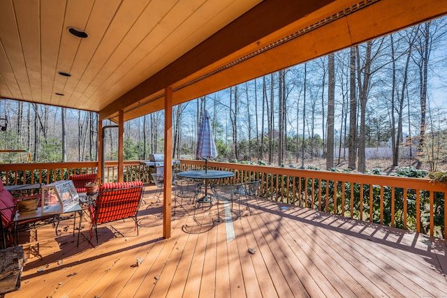 deck with outdoor dining area and a grill