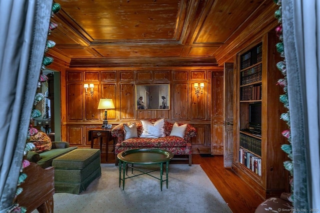 living area with crown molding, wood ceiling, wooden walls, wood finished floors, and coffered ceiling