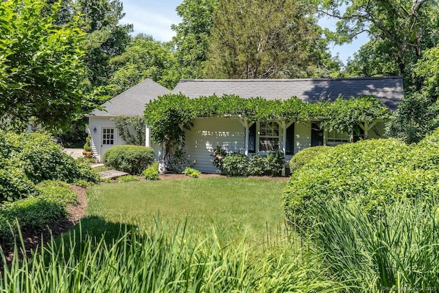 view of front of property with a front lawn and roof with shingles