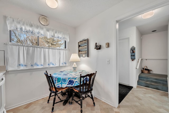 dining area with a textured ceiling and baseboards