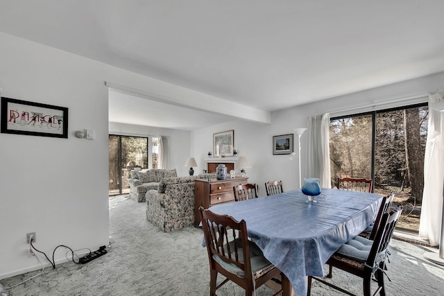 carpeted dining area featuring beamed ceiling