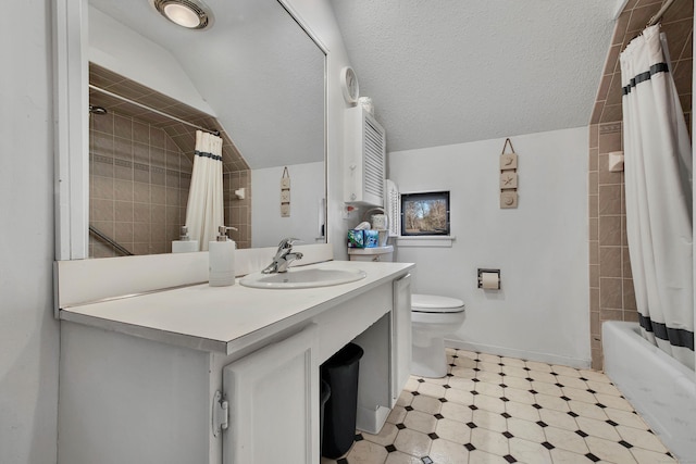 bathroom featuring a textured ceiling, lofted ceiling, toilet, vanity, and baseboards