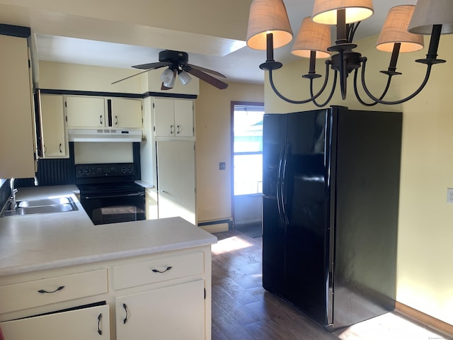 kitchen with dark wood-style flooring, under cabinet range hood, light countertops, black appliances, and a sink