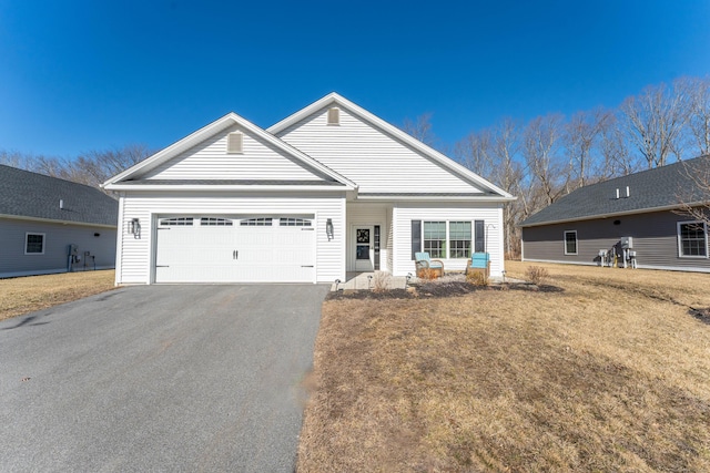 view of front of house featuring a garage, driveway, and a front lawn