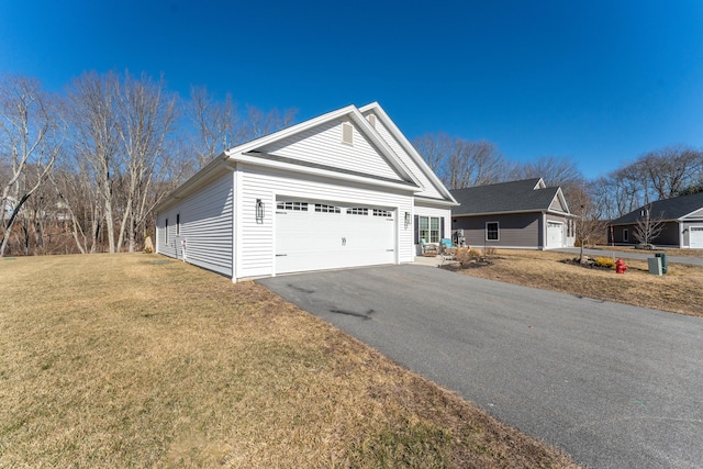 exterior space featuring driveway, a garage, and a front lawn