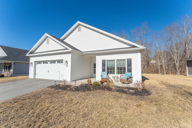 view of front of home featuring driveway, a front lawn, and an attached garage