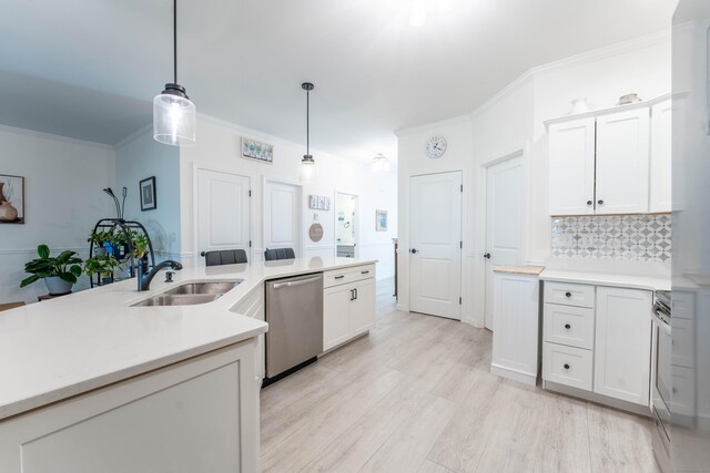 kitchen featuring light wood finished floors, appliances with stainless steel finishes, crown molding, pendant lighting, and a sink