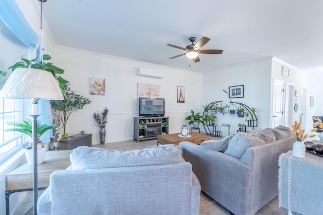 living room featuring a ceiling fan, a wall mounted air conditioner, crown molding, and light wood-style flooring