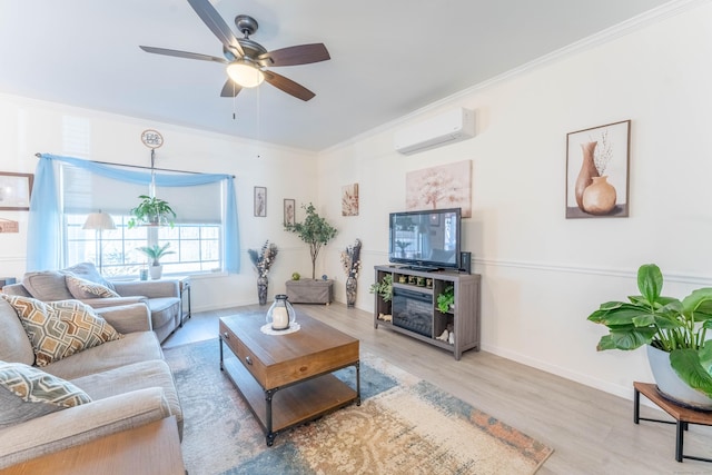 living area with a wall unit AC, ornamental molding, a ceiling fan, wood finished floors, and baseboards