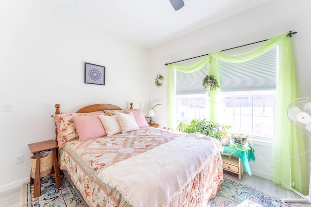 bedroom with ceiling fan, baseboards, and wood finished floors