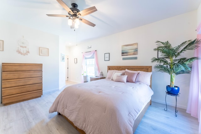 bedroom with ceiling fan, wood finished floors, and baseboards