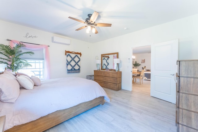 bedroom with a ceiling fan, light wood-type flooring, and an AC wall unit