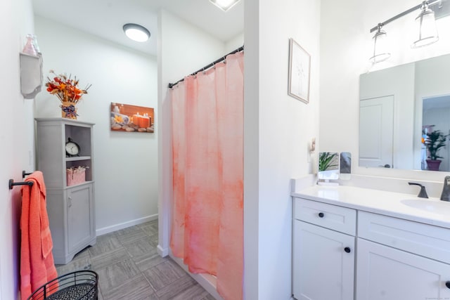 full bath featuring curtained shower, baseboards, and vanity