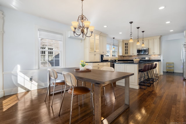 dining room featuring baseboards, dark wood-style flooring, a wall mounted air conditioner, a chandelier, and recessed lighting