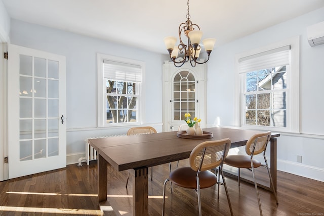 dining space featuring a wealth of natural light, a wall mounted AC, and wood finished floors