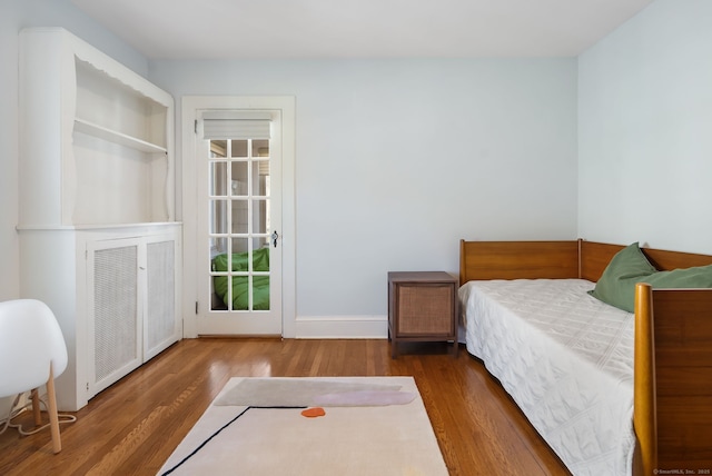 bedroom with wood finished floors, visible vents, and baseboards