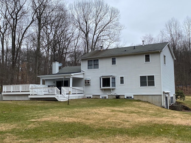 back of house featuring a deck, a lawn, and a chimney